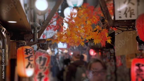 People walking through crowded japanese alley at night