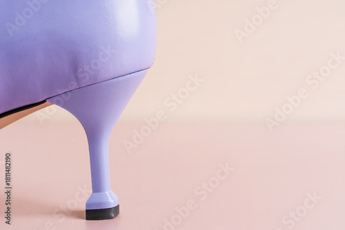 One elegant lavender color kitten heel of purple leather craft female shoe on soft pink or pastel beige background with copy space representing quality of leatherwork craftsmanship of modern footwear