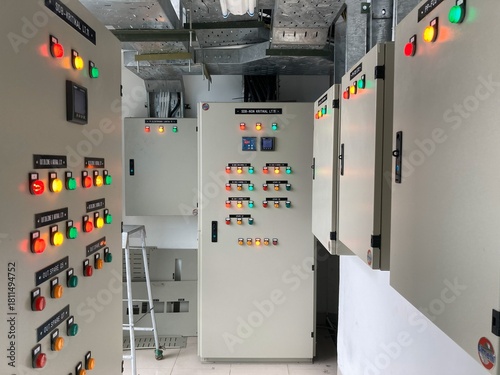 Industrial electrical control panel room with illuminated indicator lights and switches for system automation and monitoring