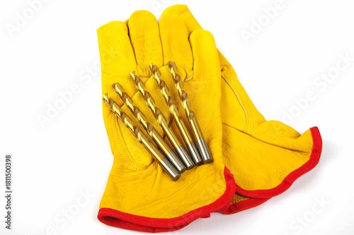 yellow leather work gloves and metal drill bits on a white background 