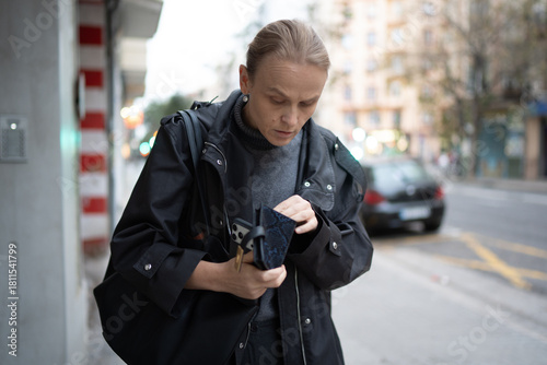 Woman checking wallet on city street
