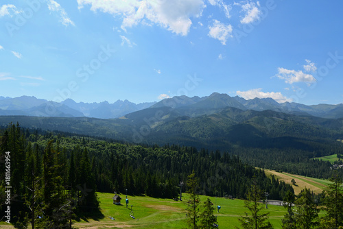 Fototapeta Naklejka Na Ścianę i Meble -  High Tatras and Male Ciche ski resort seen from a metal observation tower with a modern glass terrace offering a stunning panorama at Poronin, Poland. Majestic mountains peaks of High Tatra moutnains.