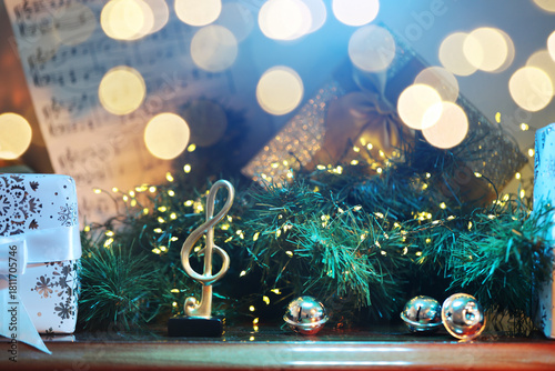 Music note and Christmas decor on wooden shelf indoors, closeup. Bokeh effect