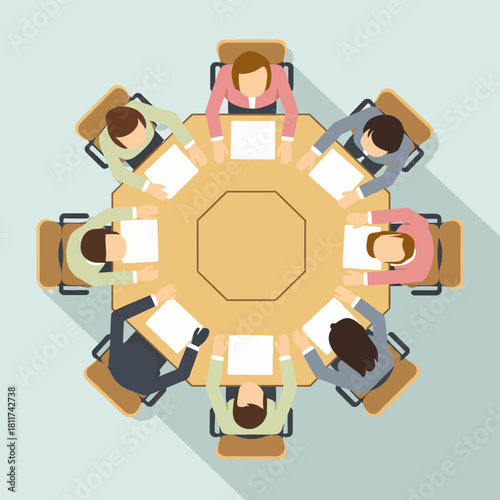 Overhead view of a diverse business team seated around a large octagonal table, engaged in a professional meeting, discussion, or collaboration at the office