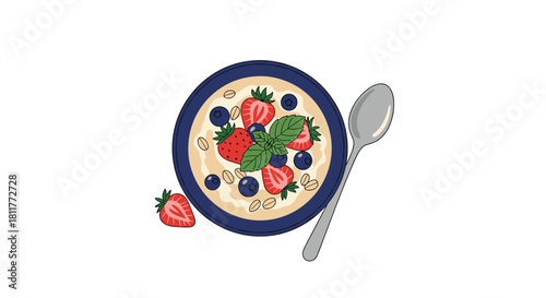 Top view of a healthy breakfast bowl of oatmeal porridge topped with fresh strawberries blueberries and mint leaves.