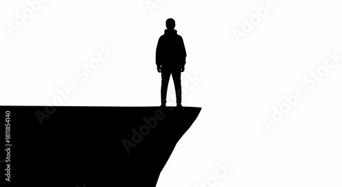 Silhouette of a person standing on a cliff edge looking out into the distance.