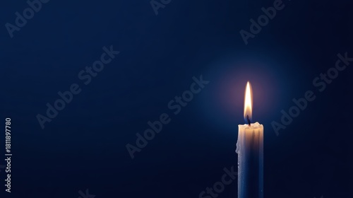 A single candle burning brightly against a dark blue background