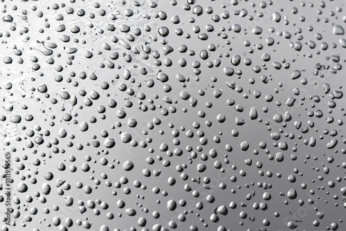 A silver, metallic surface covered with tiny droplets of water.