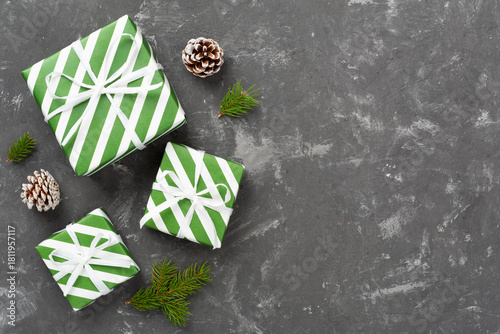 Striped Christmas gift boxes on concrete background, top view