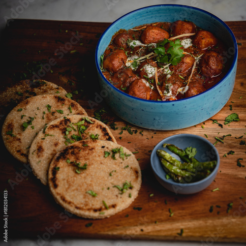 Thick, hard flatbread served alongside rich, aromatic korma—an indulgent pairing from traditional Indian cuisine.