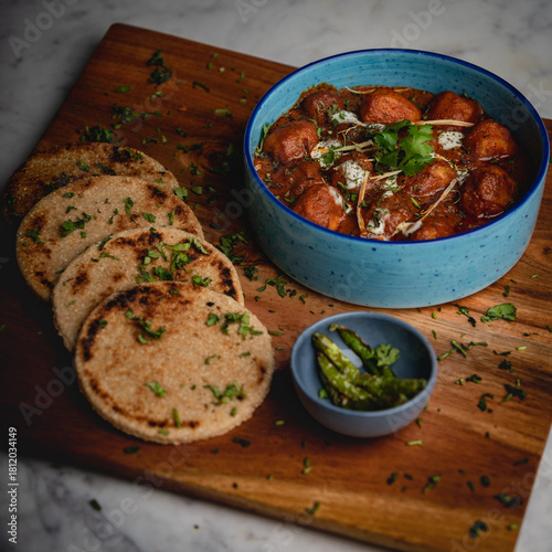 Thick, hard flatbread served alongside rich, aromatic korma—an indulgent pairing from traditional Indian cuisine.