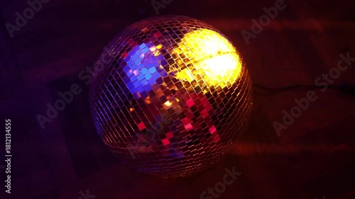 This captivating photo of a disco ball illuminated with colorful lights enhances the dance floor vibes, inviting a celebration of music, movement, and connection.