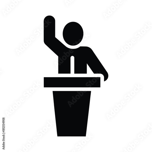 Person speaking at a podium with hand raised