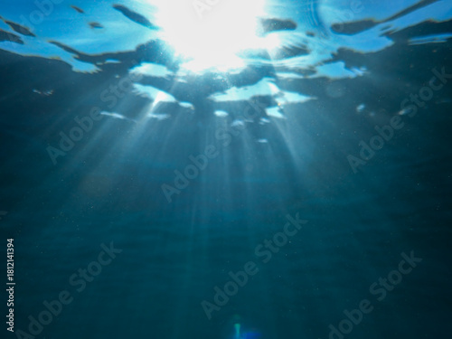 Фотография Ocean underwater rays of light background, under blue water sunlight