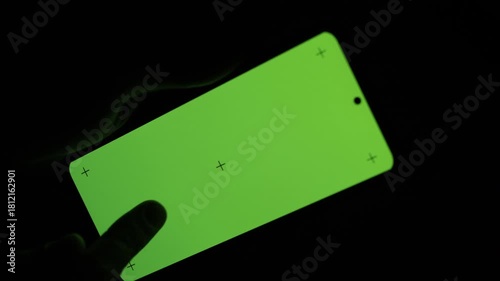 Close-up night shot of a person using a large-screen smartphone. Fingers typing text on a bright mobile display in the dark, creating a modern, high-tech atmosphere. Perfect footage for themes related