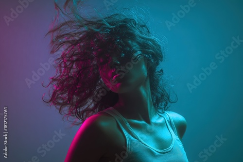 Dynamic portrait of woman with curly hair in dramatic neon pink and teal lighting