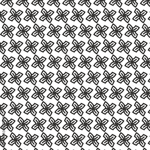 Intricate black and white floral pattern with repeating four petal flower motifs in a grid layout