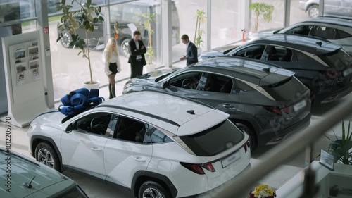 Car buyers exploring vehicles with sales agent assistance at dealership