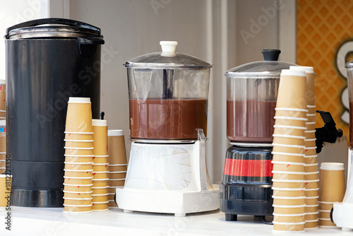 Fototapeta Naklejka Na Ścianę i Meble -  Hot chocolate dispensers with paper cups at Christmas market