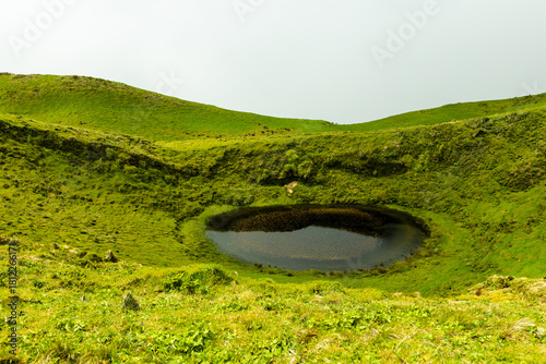 Foggy hills with green grass, lake and the mist at Sao Jorge Island, Azores, Portugal