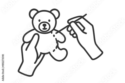Close-up view of human hands carefully stitching a small handmade teddy bear plush toy using a needle and thread during a crafting hobby