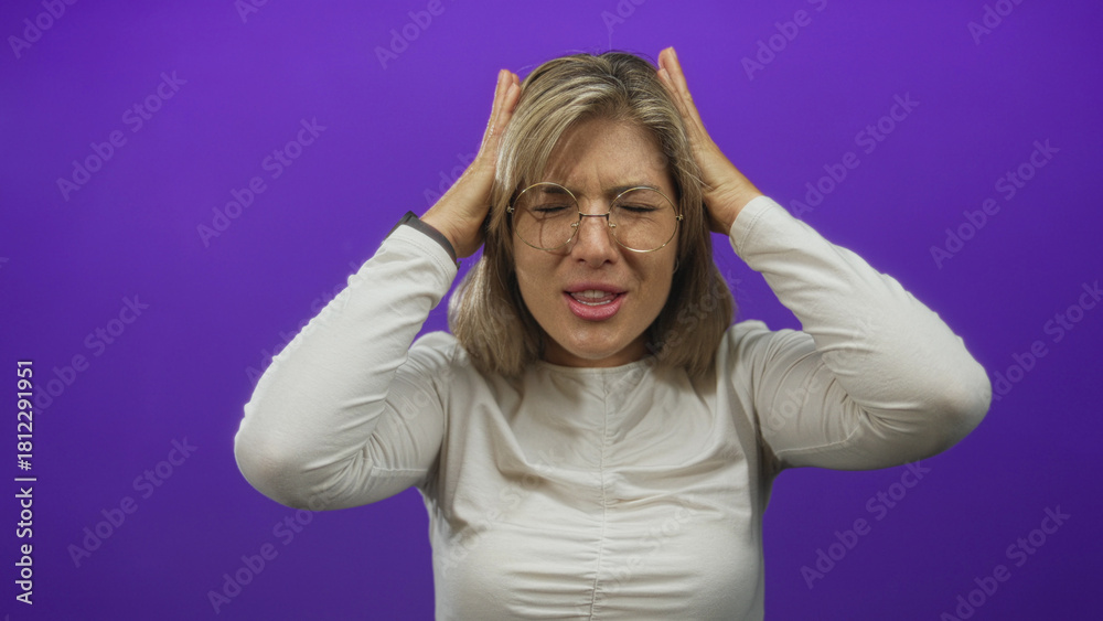 Fototapeta premium Woman shouting with raised hands in purple studio wearing white shirt and round glasses; frustration exhaustion stress.