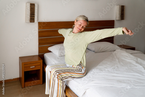 Happy Woman Wakes Up in the morning in bed at bedroom
