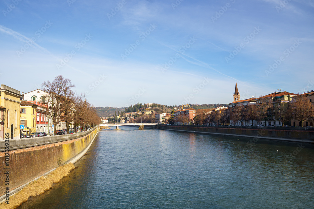 Obraz premium View of the city of Verona in Italy, across the Adige River On the left and right you can see the embankments, on the right side you can see Holmes part of the city. The sky is blue and clear