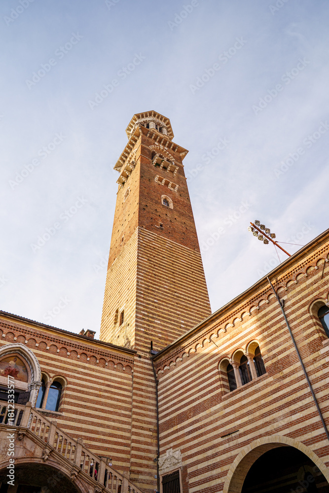 Fototapeta premium A tall rectangular tower in Verona, Italy The tower is made of red brick Part of the courtyard is visible below