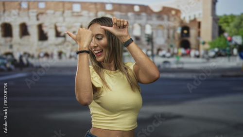 Canvas Print Woman dancing with thumbs pointing to herself and exposed belly button in front of a roman building on a busy street; joyful travel moment