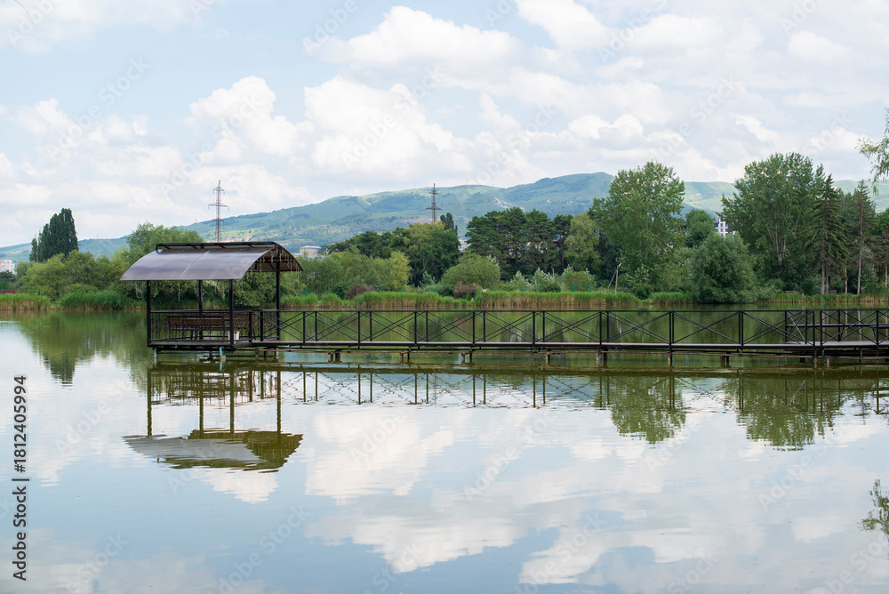 Obraz premium an iron teracce with a bridge stands on a lake in the mountains in summer and is reflected in the water