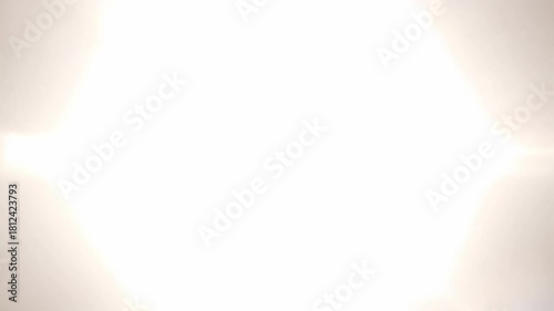 Bright light flare expanding into white screen