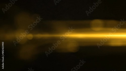 Golden lens flare sweeping across darkness