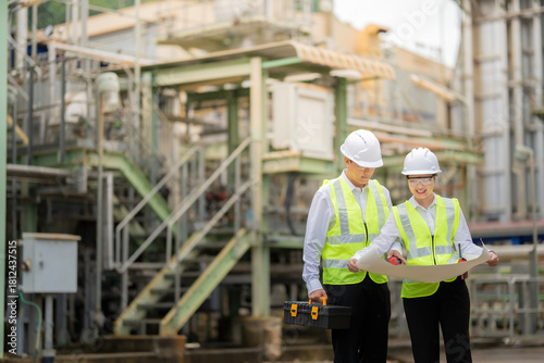 Inside the nuclear power plant, Asian male and female engineers operate high-precision machinery designed to stabilize energy production and support future advancements in the international industry.