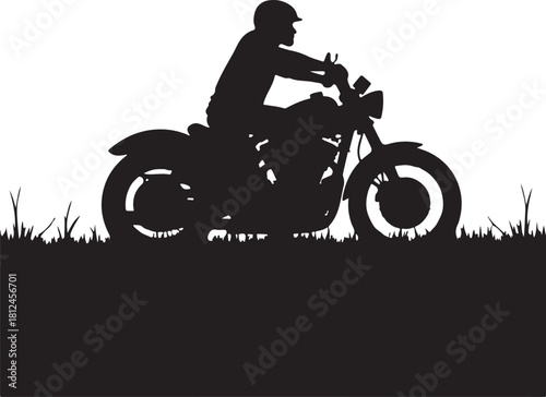 Black silhouette of a person riding a motorcycle on grass