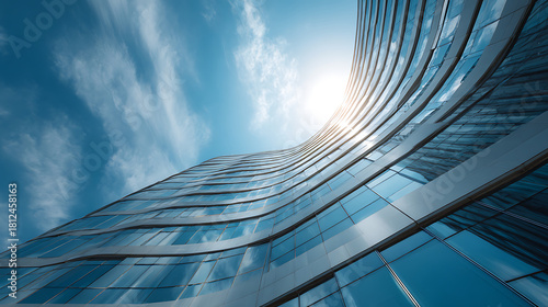 Modern glass building curves towards bright sun and blue sky modern architecture glass facade