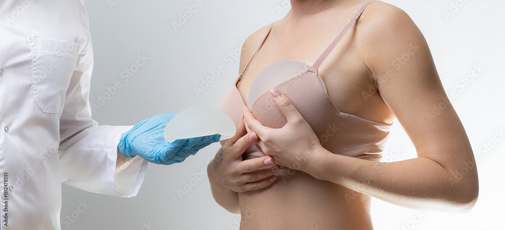 Naklejka premium Female adult with silicone breast implants in medical consultation