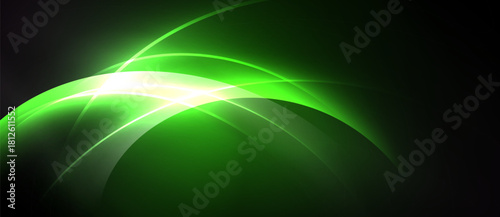 Abstract green energy flow. Bright light radiates from curves, creating dynamic visual impact. Dark background enhances luminosity.