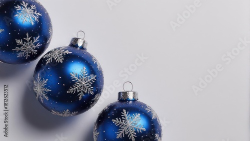Three blue Christmas ornaments with snowflake patterns on white background.