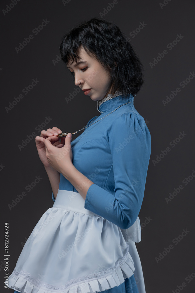 Naklejka premium Gothic-style woman in blue Victorian dress with apron, Alice in Wonderland theme