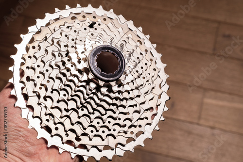 Close-up of a hand holding a multi-sprocket bicycle cassette showing gear progression and hub interface