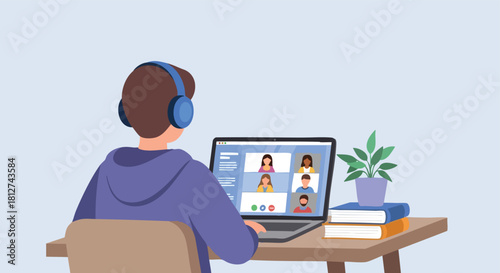 Male student wearing headphones and participating in a group video conference class or meeting on a laptop from his home desk.