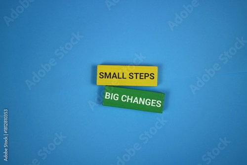 Blue background highlights two stacked blocks reading 'Small Steps' and 'Big Changes', symbolizing how tiny actions accumulate into meaningful transformation.