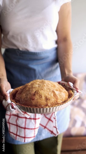 Woman holding freshly baked apple pie in home kitchen for thanksgiving celebration. Vertical video