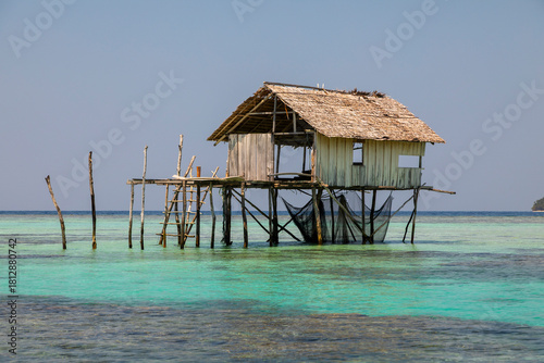 A rudimentary hut on the water, supported by logs, used as a shelter by fishermen and inhabitants of the Togian Islands, Sulawesi, Indonesia