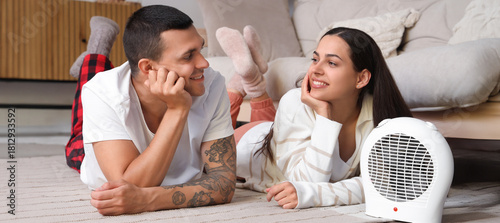 Young couple warming near e...