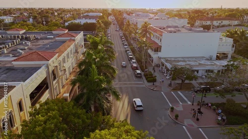 Naples Florida afternoon aerial showing 5th Avenue with luxury shops, palm trees and tourists. The orbits across 5th avenue showing boutique shops and palm tree lines avenue.