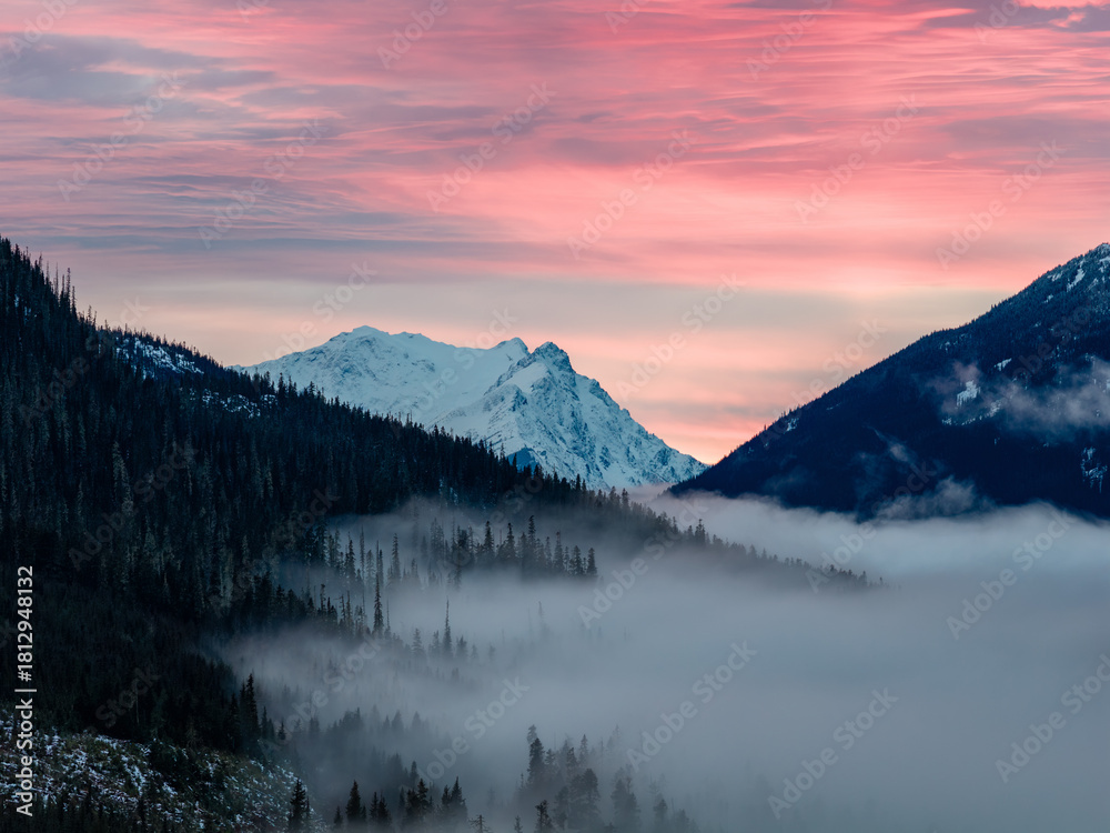 Fototapeta premium Serene Mountain Sunset Over Foggy Valley With Snow-Capped Peaks In BC, Canada