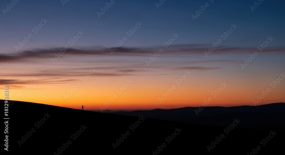 Fototapeta premium Sunset over the mountains with a vibrant orange and blue sky.