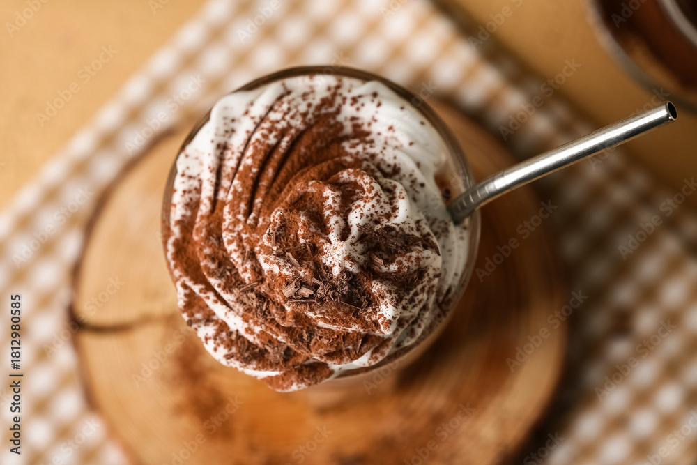 Fototapeta premium Glass of cocoa drink with whipped cream and powder, closeup